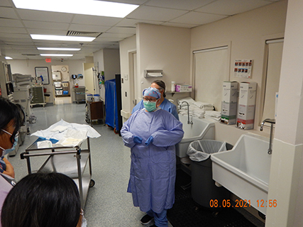 Surgical Tech shows class how to gown up
